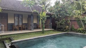 a house with a swimming pool in the yard at Werkudara Guest House in Ubud