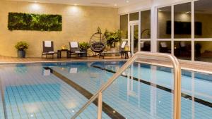 a large swimming pool with chairs in a hotel at Hotel Winterberg Resort in Winterberg