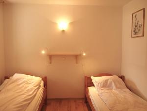 two beds in a room with a light on the wall at Lake Park Łagów in Łagów