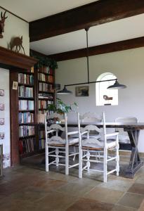 a dining room with a table and chairs and bookshelves at De Fazant in Laren