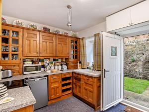 a kitchen with wooden cabinets and a white refrigerator at 2 Bed in Consett oc-96375 in Hunstanworth
