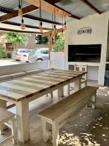 a wooden picnic table in front of a fireplace at Curahue Apart Hotel in Tandil