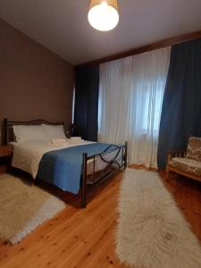 a bedroom with a bed and a couch and a window at Traditional Guesthouse Vrigiis in Agios Germanos
