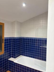a blue tiled bathroom with a bath tub at Ático centro Benicasim in Benicàssim +20 photos