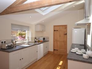 a kitchen with white cabinets and a wooden floor at 3 Bed in Bristol oc-58129 in Burrington