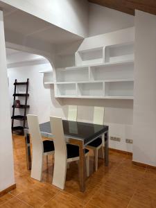 a dining room with a black table and white chairs at Ático centro Benicasim in Benicàssim