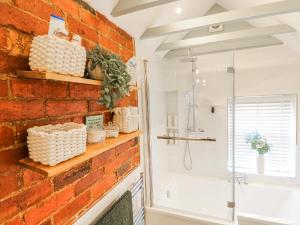 a bathroom with a red brick wall and a shower at Hill View Cottage in Ashbourne +26 photos