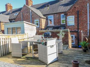 a patio with a table and chairs and a grill at Hill View Cottage in Ashbourne