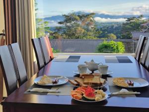 a table with plates of food on top at Kandy Alpine Breeze in Kandy