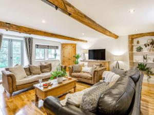 a living room with leather furniture and a tv at 3 Bed in Keighley oc-89528 in Haworth