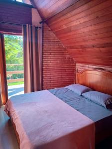 a bedroom with a large bed with a wooden wall at Pousada Finca dos Anjos in Passa Quatro +38 photos