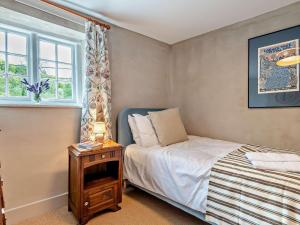 a bedroom with a bed and a window and a table at 3 Bed in Salisbury oc-95325 in Amesbury
