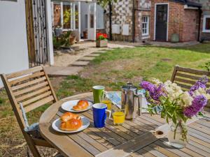 a wooden table with plates of food and flowers on it at 3 Bed in Salisbury oc-95325 in Amesbury +18 photos