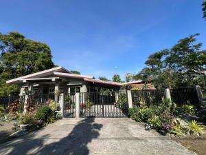a house with a gate in a driveway at Aquino Stays in Luna