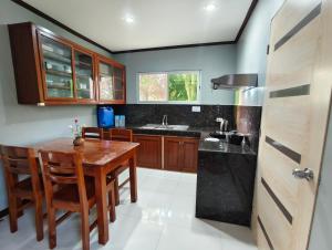 a kitchen with a wooden table and wooden cabinets at Aquino Stays in Luna