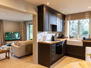 a kitchen with brown cabinets and a living room at 1 Bed in Ripon oc-95074 in Dishforth
