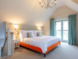 a bedroom with a large bed and a chandelier at 1 Bed in Ripon oc-95074 in Dishforth
