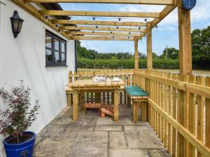 a deck with a wooden pergola and a table and benches at 1 Bed in Southampton oc-92943 in Chalbury