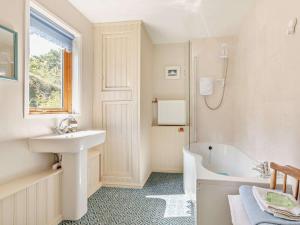 a white bathroom with a sink and a bath tub at 3 Bed in Watchet oc-95161 in Washford +9 photos
