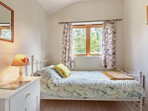 a bedroom with a bed and a window at 3 Bed in Watchet oc-95161 in Washford