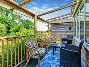 a patio with chairs and tables on a deck at 3 Bed in Watchet oc-95161 in Washford