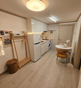 a kitchen with a white refrigerator and a table at 건대역5분 성수 감성숙소 5 min walk to Konkok Univ Station # 6-Minute Walk to Airport Limousine # Seongsu Cafe Street Walking Tour Hotspots & Pop-up Stores #Seoul Forest # Thukseom Han River Park #KSPO # COEX #Gangnam in Seoul +27 photos