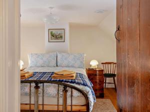 a bedroom with a bed with a blue and white blanket at 1 Bed in Bristol oc-95178 in Blagdon