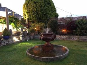 a fountain in the middle of a yard at Bradleigh Lodge in St Austell