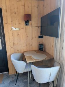 a table and two chairs in a room with wooden walls at Onder de Oude Walnoot in Sint Pancras