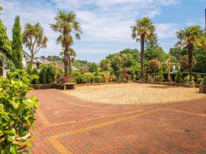 a brick driveway with palm trees in a park at Bradleigh Lodge in St Austell
