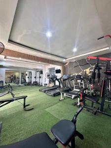 a gym with a bunch of tread machines in it at FortExcel Hotels & Suites in Odogun
