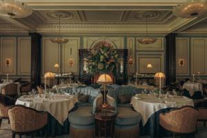 a dining room with tables and chairs and flowers at The Gleneagles Hotel in Auchterarder +125 photos