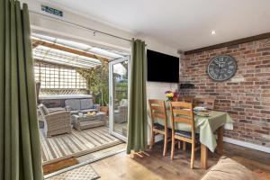 a living room with a table and chairs and a brick wall at Ffynnonlwyd Cottage - rural holiday cottage with hot tub in Llangynin