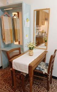 a dining room table with a vase of flowers on it at Centralissimo e vicinissimo alla spiaggia , RILO Studio in Vernazza