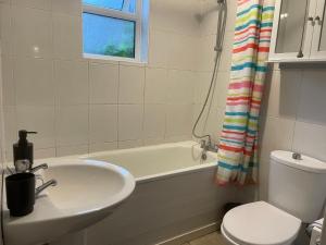 a bathroom with a sink and a tub and a toilet at Spacious Central Reading Flat, 2 Double Beds, Wi-Fi, Parking in Reading +10 photos