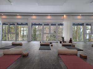 a room with a yoga class with large windows at Hotel Winterberg Resort in Winterberg