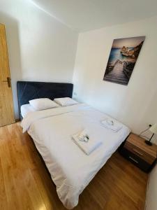a bedroom with a white bed with two towels on it at Apartment ADEPTO in Sveti Jakov