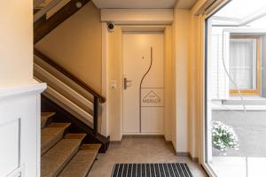 a hallway with stairs and a door with a mexican sign on it at Herti14 Serviced Apartments in Ennetbaden