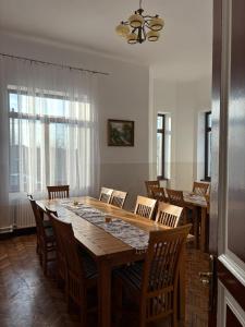 a dining room with a large wooden table and chairs at Conacul Maria in Ocna-Mureşului