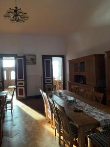 a dining room with a large wooden table and chairs at Conacul Maria in Ocna-Mureşului +6 photos
