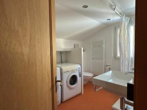 a bathroom with a washing machine and a sink at Revier Schwettiberg Nr. 1 in Braunwald
