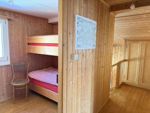 a small room with a bunk bed and a chair at Revier Schwettiberg Nr. 1 in Braunwald