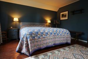 a bedroom with a bed with a blanket on it at De Fazant in Laren