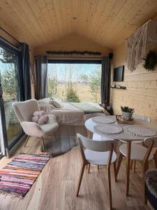 a bedroom with a bed and a table and chairs at ToTu Tiny House Sauna & wanna ogrodowa in Dobiesz