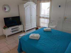 a bedroom with a blue bed and a tv at B&B Casa De Mare in Lido Marini