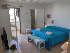 a bedroom with a blue bed and a tv at B&B Casa De Mare in Lido Marini