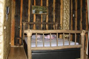 a wooden bed in a room with wooden walls at Hotel Pomeschik in Krasnodar