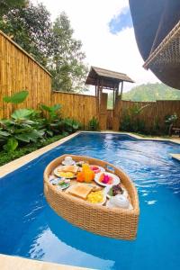 a tray of food in a basket in the middle of a swimming pool at Hidden Bamboo Village in Sidemen