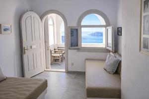 a bedroom with an open door with a view of the ocean at Yposkafo Suites - Private Studio - Santorini in Fira