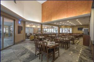 a dining room with tables and chairs in a restaurant at Actuall Convention Hotel in Contagem